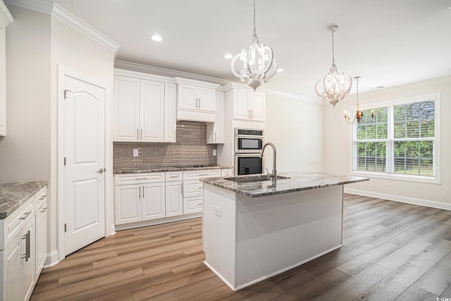 1476 Burriss Rd, Conway, SC 29526 - kitchen featuring a chandelier, a sink, crown molding, light wood-style flooring, and white cabinetry