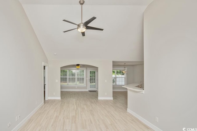 231 Marbella Dr, Murrells Inlet, SC 29576 - unfurnished living room with ceiling fan, high vaulted ceiling, baseboards, light wood-style flooring, and a sink