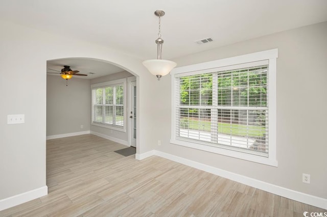 231 Marbella Dr, Murrells Inlet, SC 29576 - unfurnished room with baseboards, a ceiling fan, light wood-style flooring, and arched walkways