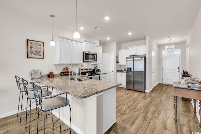 1170 Maxwell Dr, Little River, SC 29566 - kitchen with appliances with stainless steel finishes, a sink, a peninsula, light stone countertops, and white cabinets