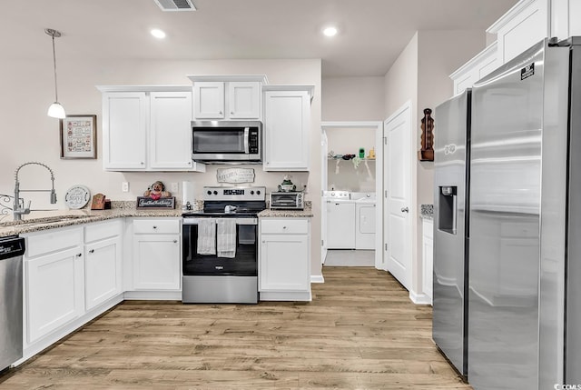 1170 Maxwell Dr, Little River, SC 29566 - kitchen featuring stainless steel appliances, a sink, washing machine and dryer, white cabinets, and recessed lighting