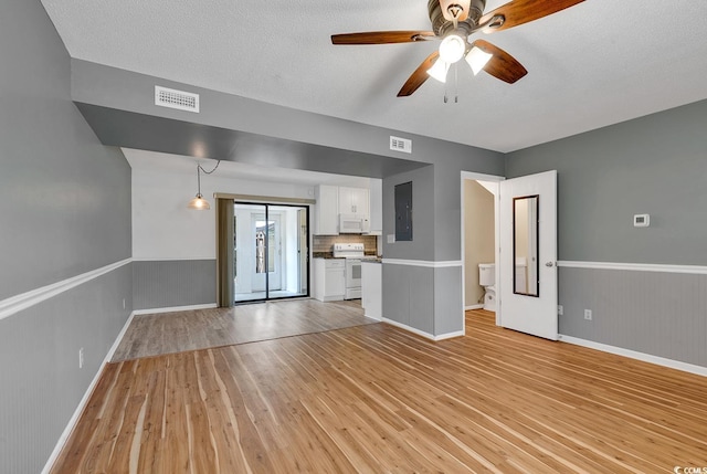 633 Sparrow Dr Unit B, Surfside Beach, SC 29575 - unfurnished living room with light wood-type flooring, ceiling fan, baseboards, and a textured ceiling