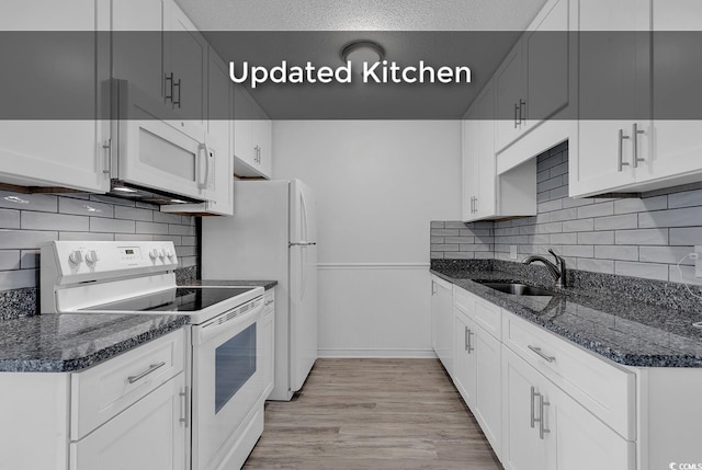 633 Sparrow Dr Unit B, Surfside Beach, SC 29575 - kitchen with white appliances, a sink, light wood finished floors, dark stone counters, and decorative backsplash