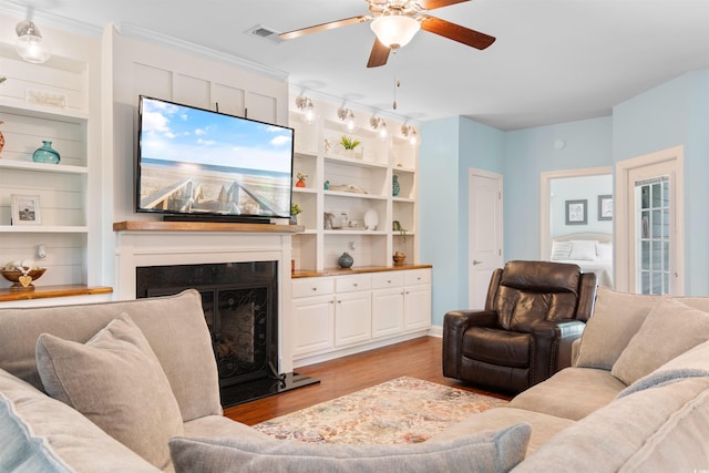 116 Chapel Ridge Cir, Myrtle Beach, SC 29588 - living room with ceiling fan, light wood-type flooring, a fireplace with raised hearth, and built in shelves