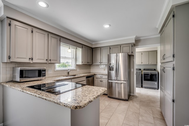 3334 Cedar Creek Run, Little River, SC 29566 - kitchen with appliances with stainless steel finishes, washing machine and dryer, ornamental molding, a peninsula, and a sink