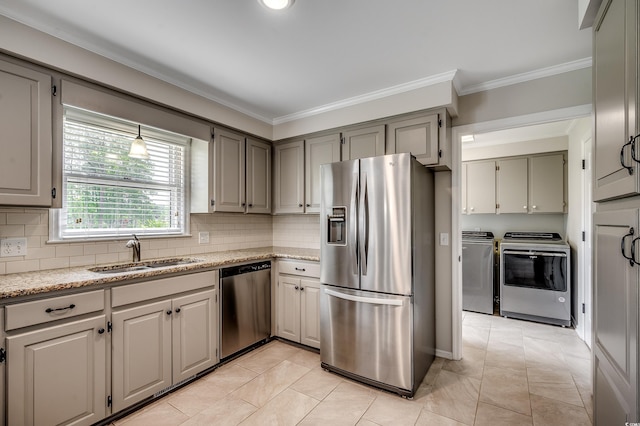 3334 Cedar Creek Run, Little River, SC 29566 - kitchen featuring appliances with stainless steel finishes, a sink, washing machine and dryer, ornamental molding, and tasteful backsplash