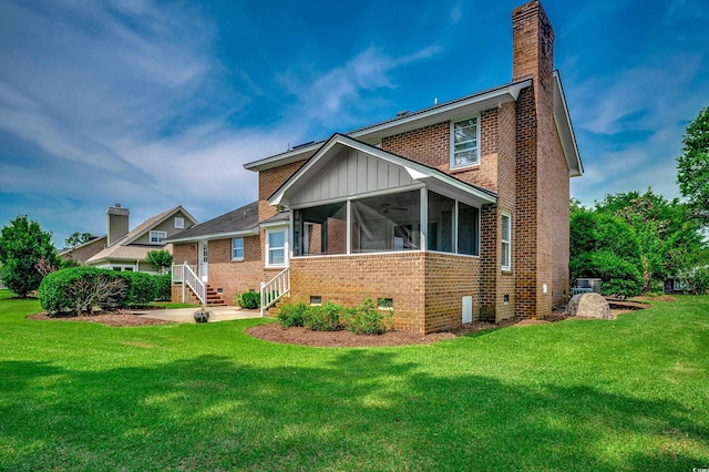 3334 Cedar Creek Run, Little River, SC 29566 - rear view of house with a sunroom, a chimney, brick siding, and a yard