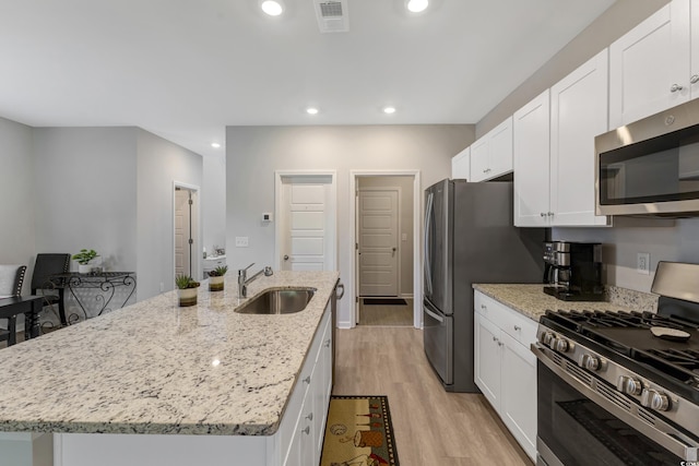 120 Carolina Lakes Blvd, Myrtle Beach, SC 29588 - kitchen featuring stainless steel appliances, a sink, a center island with sink, white cabinetry, and light wood finished floors
