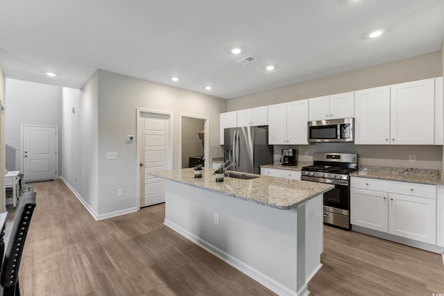120 Carolina Lakes Blvd, Myrtle Beach, SC 29588 - kitchen featuring appliances with stainless steel finishes, a sink, wood finished floors, a center island with sink, and white cabinets