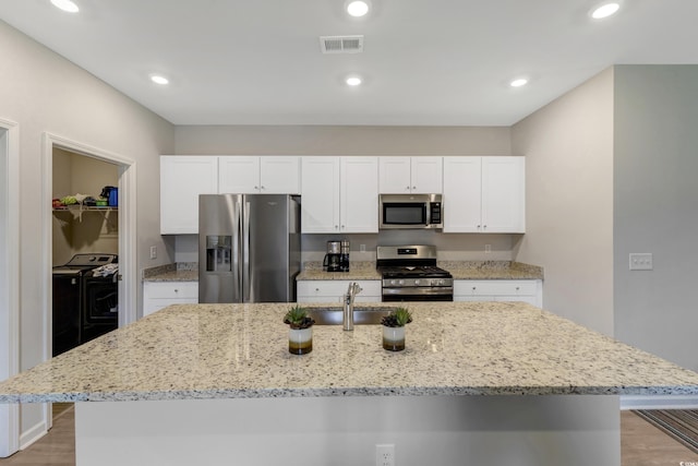 120 Carolina Lakes Blvd, Myrtle Beach, SC 29588 - kitchen featuring appliances with stainless steel finishes, a sink, washing machine and clothes dryer, light wood-type flooring, and recessed lighting