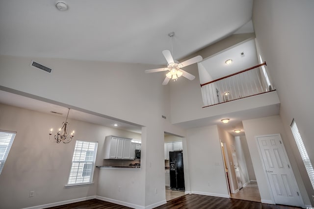 422 S Poplar Dr, Surfside Beach, SC 29575 - unfurnished living room with a chandelier, a high ceiling, plenty of natural light, ceiling fan, and baseboards