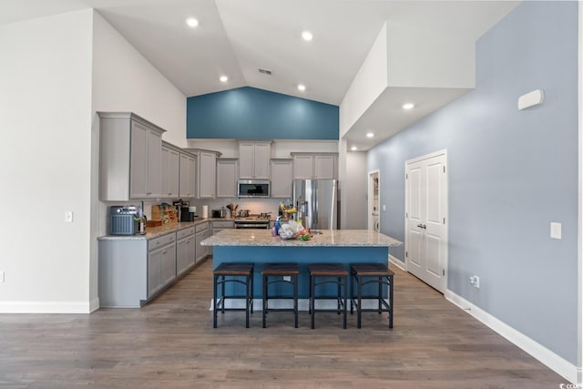 720 Little Fawn Way, Myrtle Beach, SC 29579 - kitchen featuring appliances with stainless steel finishes, gray cabinets, a kitchen bar, a kitchen island, and high vaulted ceiling