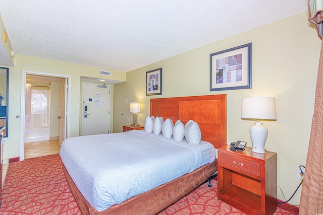 504 N Ocean Blvd Unit 1804A/B, Myrtle Beach, SC 29577 - bedroom with a textured ceiling, tile patterned flooring, and connected bathroom