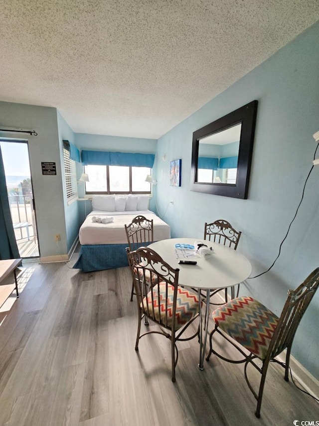 1605 S Ocean Blvd S Unit 105, Myrtle Beach, SC 29577 - bedroom featuring wood finished floors, a textured ceiling, access to outside, and baseboards
