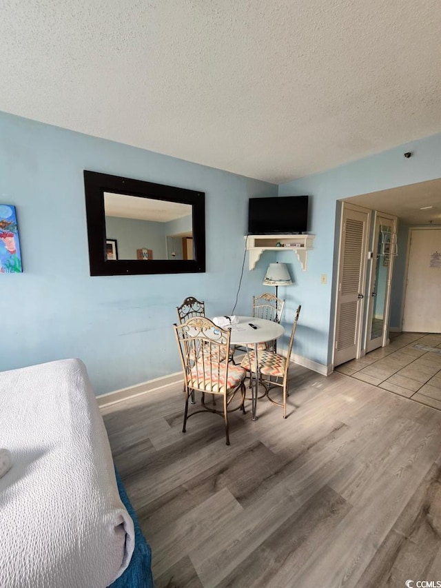 1605 S Ocean Blvd S Unit 105, Myrtle Beach, SC 29577 - dining area featuring a textured ceiling, wood finished floors, and baseboards