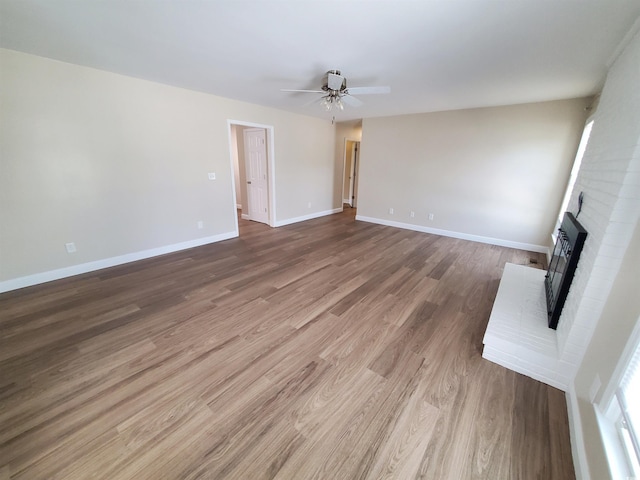 302 Silver Fox Trl, Myrtle Beach, SC 29588 - unfurnished living room with a ceiling fan, a fireplace, wood finished floors, and baseboards