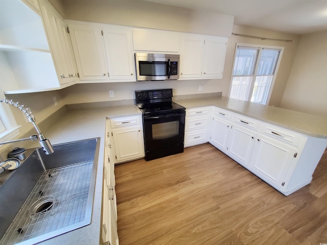 302 Silver Fox Trl, Myrtle Beach, SC 29588 - kitchen with stainless steel microwave, black electric range oven, white cabinets, and a sink