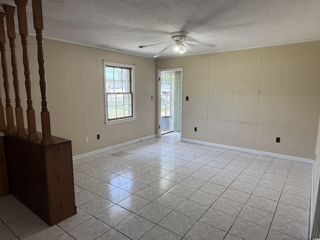 1002 S Beech Ave, Andrews, SC 29510 - spare room with a ceiling fan, ornamental molding, light tile patterned floors, baseboards, and wood walls