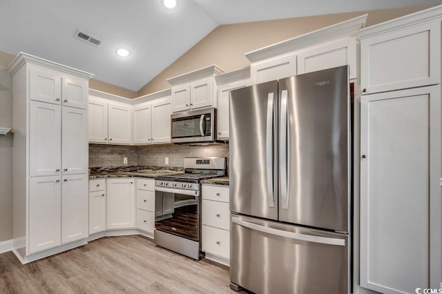 3129 Slade Dr, Conway, SC 29526 - kitchen with appliances with stainless steel finishes, vaulted ceiling, light wood finished floors, decorative backsplash, and white cabinetry