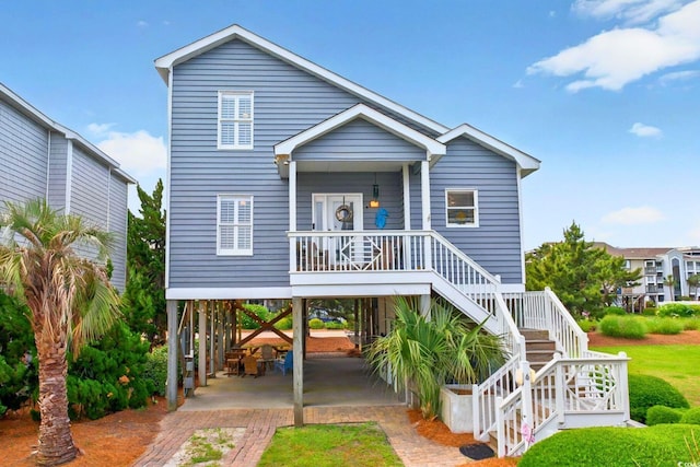 6 Indigo Ct, Ocean Isle Beach, NC 28469 - beach home with a carport, a porch, stairway, and driveway