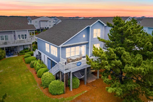 6 Indigo Ct, Ocean Isle Beach, NC 28469 - back of house with roof with shingles, a yard, a residential view, and a deck
