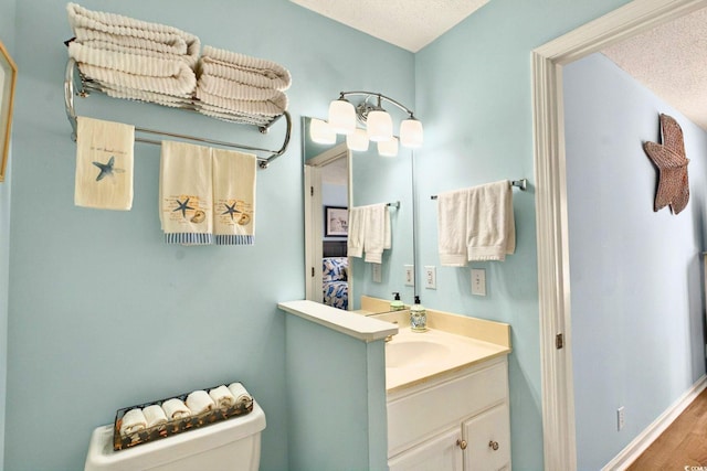 6 Indigo Ct, Ocean Isle Beach, NC 28469 - bathroom featuring vanity, toilet, a textured ceiling, and wood finished floors