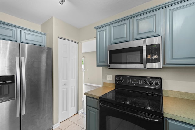 4013 Blackwolf Dr, Myrtle Beach, SC 29579 - kitchen featuring stainless steel appliances, blue cabinetry, light tile patterned flooring, and baseboards