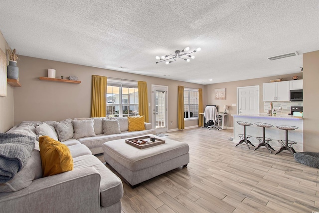 104 Clovis Cir, Myrtle Beach, SC 29579 - living area featuring light wood-style floors, a textured ceiling, and a chandelier