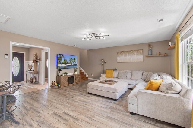 104 Clovis Cir, Myrtle Beach, SC 29579 - living room with light wood-style floors, a textured ceiling, a chandelier, and stairs