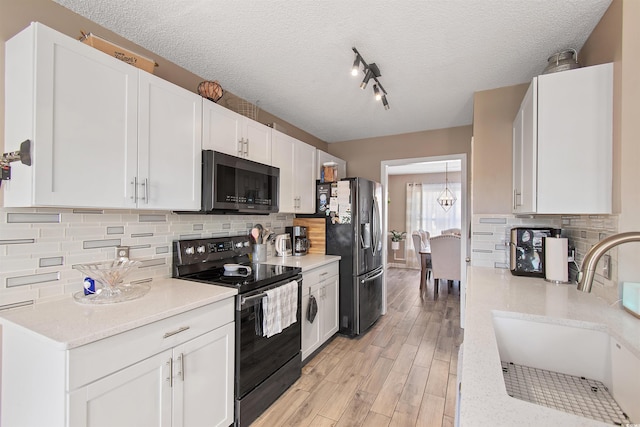 104 Clovis Cir, Myrtle Beach, SC 29579 - kitchen with black range with electric cooktop, fridge with ice dispenser, a sink, light wood finished floors, and white cabinetry