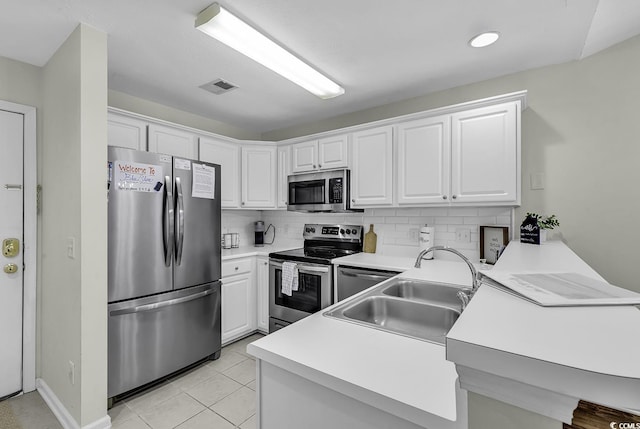 598 Blue Stem Dr Unit 52E, Pawleys Island, SC 29585 - kitchen with stainless steel appliances, a peninsula, tasteful backsplash, white cabinetry, and a sink