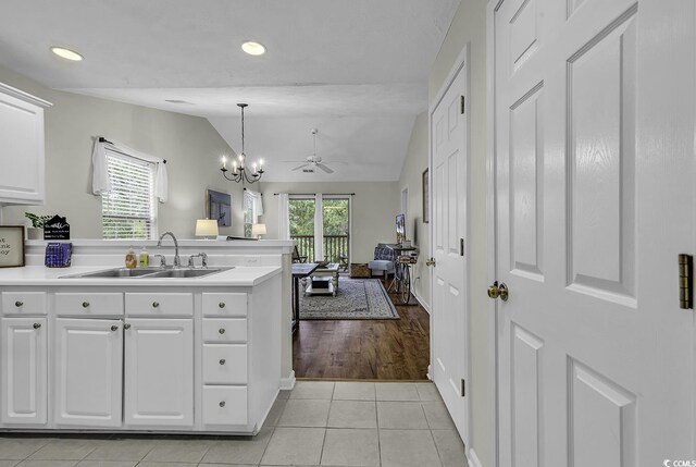 598 Blue Stem Dr Unit 52E, Pawleys Island, SC 29585 - kitchen featuring a sink, lofted ceiling, white cabinetry, a peninsula, and light tile patterned floors