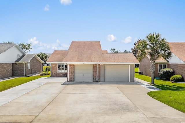 502 Garden Dr, Surfside Beach, SC 29575 - view of front of house with a garage, driveway, a front yard, and brick siding