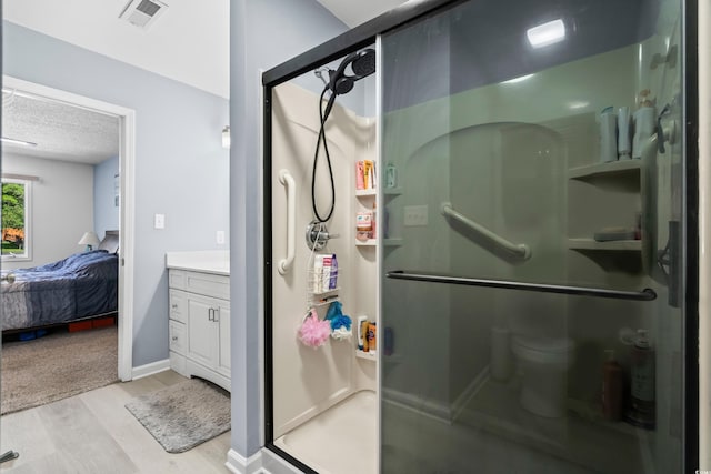 502 Garden Dr, Surfside Beach, SC 29575 - bathroom featuring a shower stall, wood finished floors, vanity, a textured ceiling, and ensuite bath