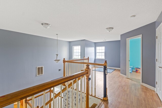 1033 Mccall Loop, Conway, SC 29526 - hall featuring an upstairs landing, light wood-type flooring, baseboards, and a textured ceiling