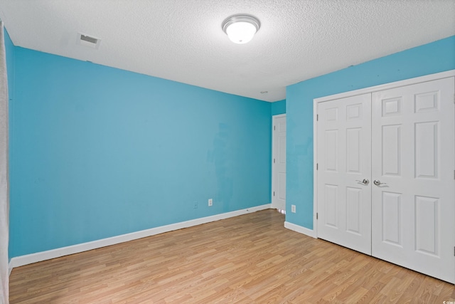 1033 Mccall Loop, Conway, SC 29526 - unfurnished bedroom with light wood-style flooring, a textured ceiling, a closet, and baseboards