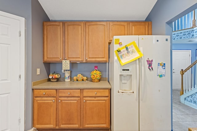 1033 Mccall Loop, Conway, SC 29526 - kitchen featuring white fridge with ice dispenser, light tile patterned flooring, light countertops, brown cabinets, and a textured ceiling