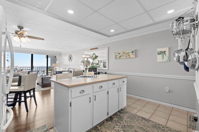 1210 N Waccamaw Dr Unit 1105, Murrells Inlet, SC 29576 - kitchen with crown molding, light countertops, a kitchen island, white cabinets, and a ceiling fan