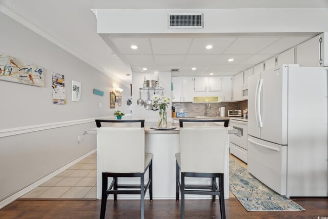 1210 N Waccamaw Dr Unit 1105, Murrells Inlet, SC 29576 - kitchen featuring white appliances, recessed lighting, decorative backsplash, a kitchen island, and white cabinetry