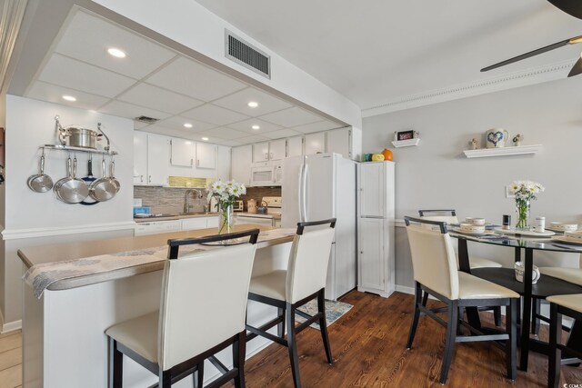 1210 N Waccamaw Dr Unit 1105, Murrells Inlet, SC 29576 - kitchen featuring white appliances, decorative backsplash, recessed lighting, light countertops, and white cabinetry