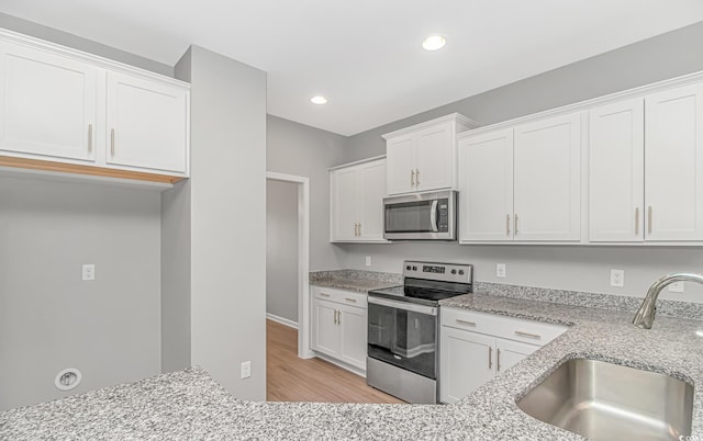 3539 Harrelson Ave, Loris, SC 29569 - kitchen with appliances with stainless steel finishes, a sink, light stone counters, white cabinets, and recessed lighting