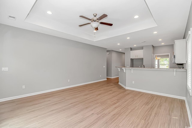 3539 Harrelson Ave, Loris, SC 29569 - unfurnished living room with a raised ceiling, ceiling fan, recessed lighting, light wood-style floors, and baseboards