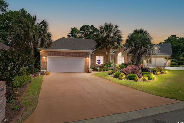 2567 Lake Vista Dr, Little River, SC 29566 - view of front facade with concrete driveway, an attached garage, brick siding, and a front yard