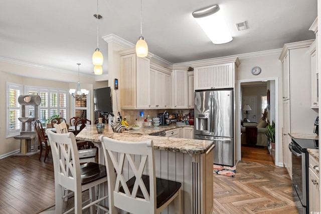 2567 Lake Vista Dr, Little River, SC 29566 - kitchen featuring appliances with stainless steel finishes, a peninsula, light stone countertops, a kitchen breakfast bar, and crown molding