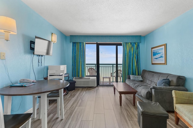 2207 S Ocean Blvd Unit 1517, Myrtle Beach, SC 29577 - living area with a textured ceiling, wood finished floors, a wall mounted AC, and a desk