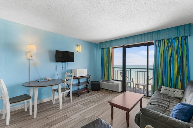 2207 S Ocean Blvd Unit 1517, Myrtle Beach, SC 29577 - living area featuring a textured ceiling, wood finished floors, baseboards, and a wall mounted AC