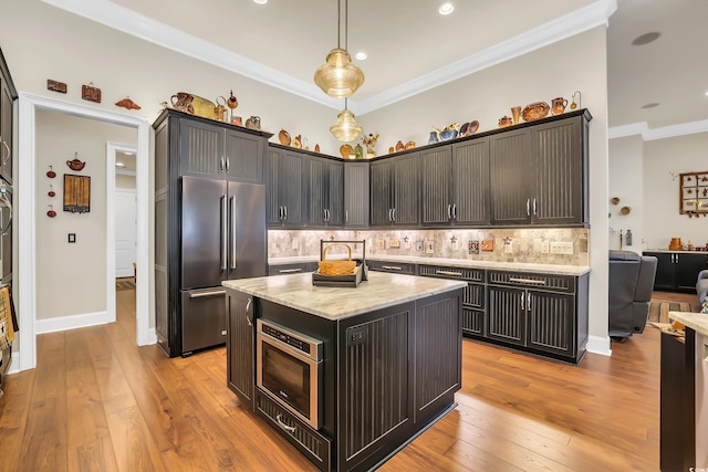81 Cascade Dr, Murrells Inlet, SC 29576 - kitchen featuring appliances with stainless steel finishes, decorative backsplash, light stone countertops, ornamental molding, and light wood-style floors