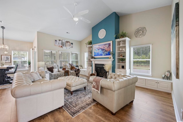 2300 Lark Sparrow St, Myrtle Beach, SC 29577 - living room featuring high vaulted ceiling, a glass covered fireplace, ceiling fan, wood finished floors, and a chandelier