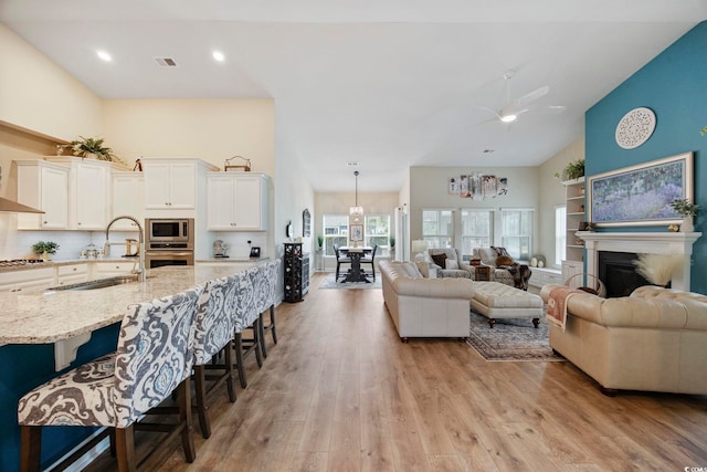 2300 Lark Sparrow St, Myrtle Beach, SC 29577 - living room featuring a ceiling fan, light wood-style floors, a towering ceiling, a fireplace, and recessed lighting