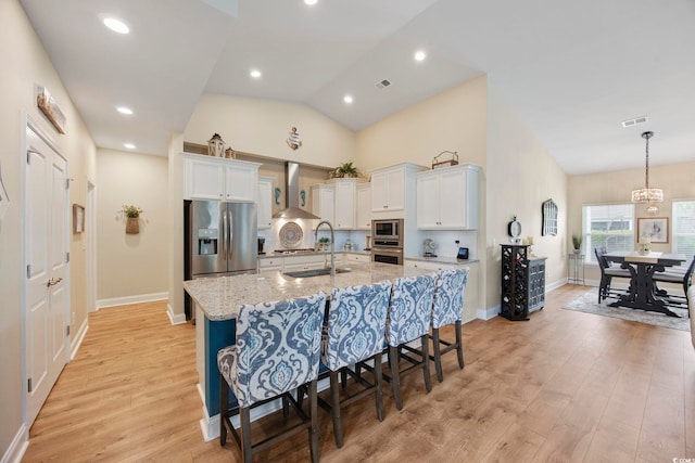 2300 Lark Sparrow St, Myrtle Beach, SC 29577 - kitchen featuring wall chimney range hood, a sink, appliances with stainless steel finishes, a kitchen island with sink, and a kitchen bar